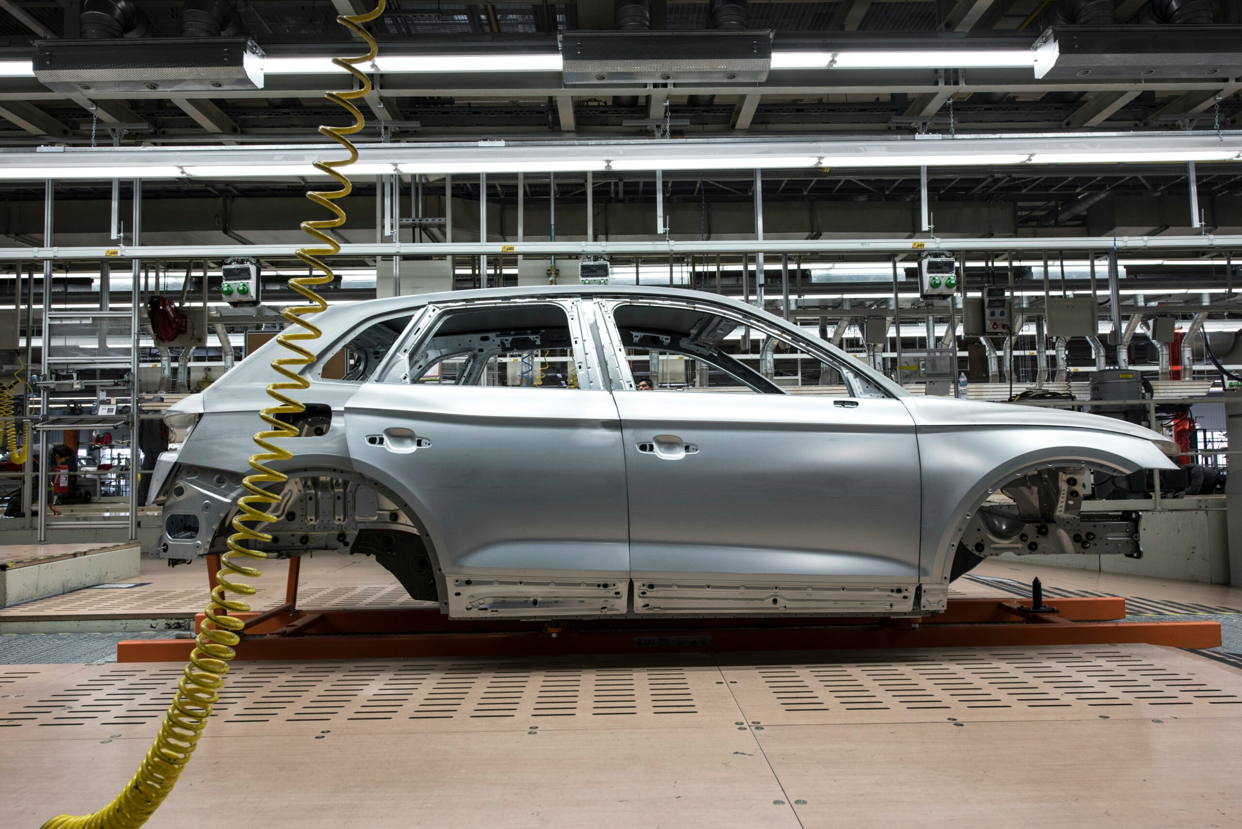 Car manufacturing plant illustrating supply chain impact relevant to best forex prop trading firms