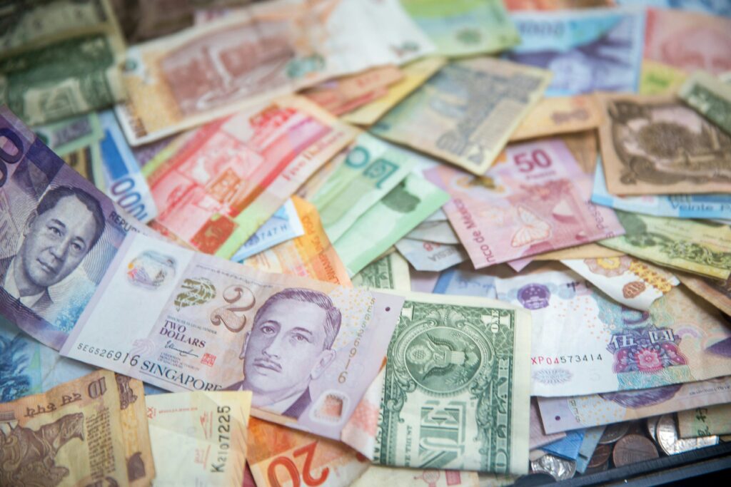 Stacks of international currencies representing forex trading and one step evaluation prop firm strategies